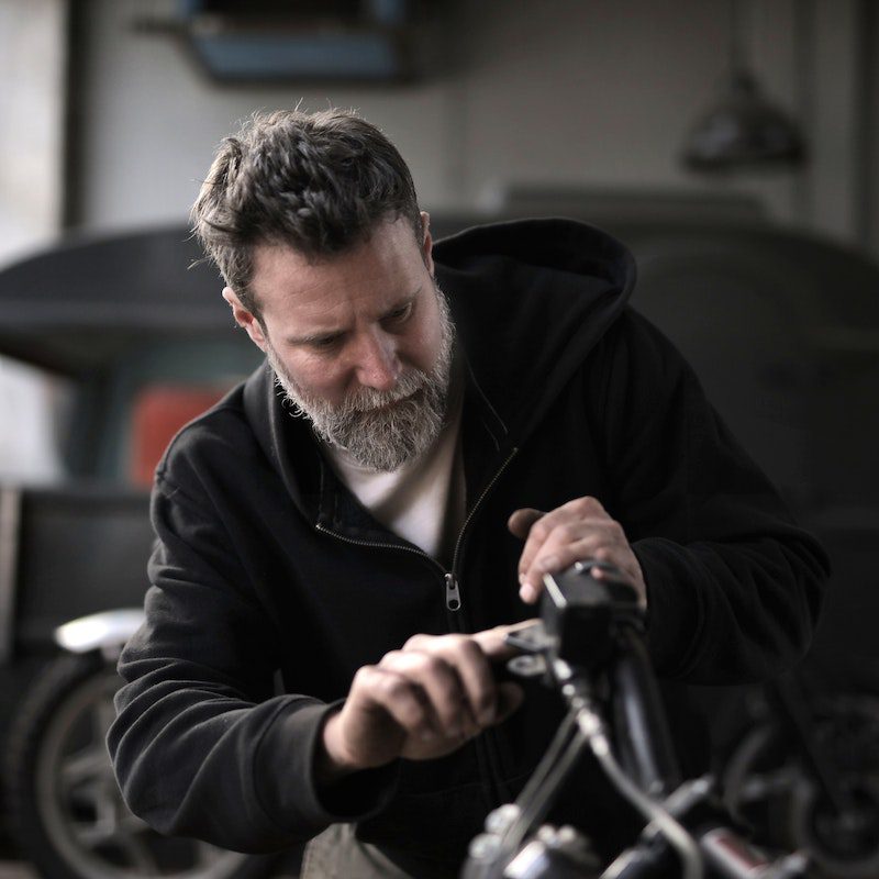Brutal man repairing e-bike in workshop